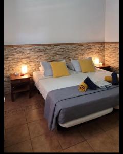 una camera da letto con due letti e un muro di mattoni di Eden GuestHouse a Sardina