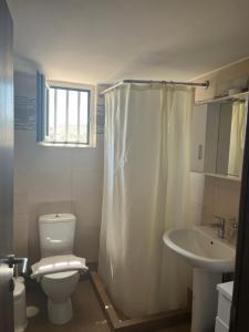 a white bathroom with a toilet and a sink at Niko's apartments 1 in Elafonisos