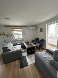 a living room with two couches and a table at Apartman Biser in Sarajevo