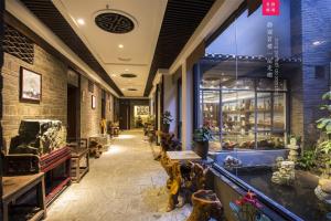 a store hallway with a large window and tables and chairs at Aroma Tea House Former Jing Guan Ming Lou Museum Hotel in Guilin