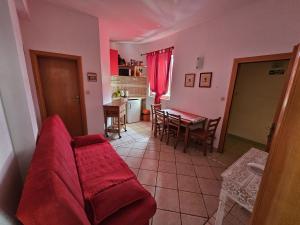 a living room with a red couch and a table at Apartmani Katja in Omiš +14 photos