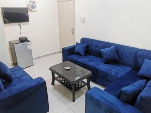 a living room with a blue couch and a table at Romero hotel apartments in Aqaba