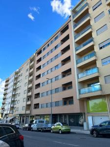 a large building with cars parked in front of it at Apartamento Braguinha in Bragança