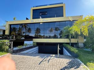 un edificio con palme di fronte di Mar do cabo Branco by Allmare Temporada a João Pessoa