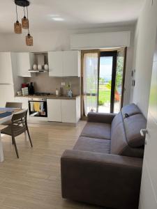 ein Wohnzimmer mit Couch und Tisch und eine Küche in der Unterkunft Stella di Mare in Montesilvano