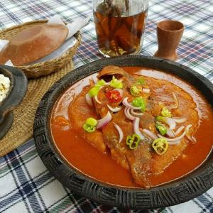 a bowl of soup with onions and peppers on a table at Hôtel Chez Jules 229 