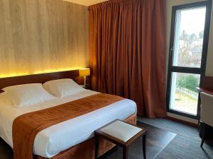 a hotel room with a large bed and a window at Hotel du Casino in Saint-Valéry-en-Caux