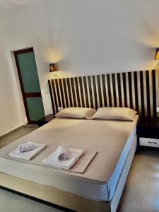 a bedroom with a bed with towels on it at Aleks Holiday Rooms in Ksamil