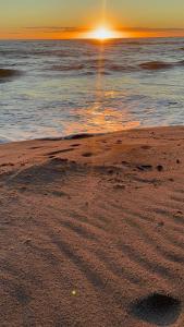 een strand met de zon die ondergaat boven de oceaan bij Vieira Mar jorlandia in Aracati