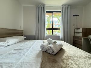 una camera da letto con un letto con asciugamani sopra di Luxor Paulo Miranda by Allmare Temporada a João Pessoa Altre 27 foto