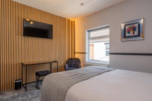 a bedroom with a bed and a tv on a wall at Super Stylish and Vibrant 3 Bed Getaway in Hull