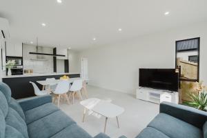 a living room with a couch and a table at Brand New 3Bedrooms House in The Base Te Rapa in Hamilton