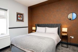 a bedroom with a bed with a black and white comforter at Super Stylish and Vibrant 3 Bed Getaway in Hull