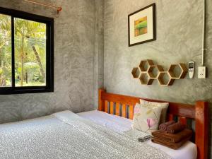 une chambre avec un lit et une fenêtre dans l'établissement Longhaad Lanta garden resort, à Ban Ai Dao