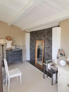 ein Wohnzimmer mit einer Kommode und einem Spiegel in der Unterkunft Le mazet des Galinières in Allegre Les Fumades