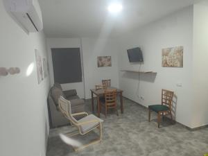 a living room with a table and chairs and a tv at Apartamentos Turísticos Atalaya in Minas de Ríotinto