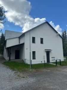 a large white building with a garage at Apartmán Lesní ráj in Svratouch