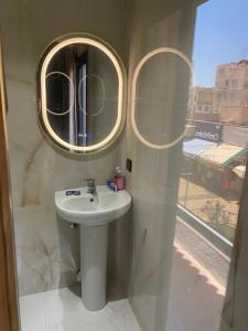 a bathroom with a sink and two mirrors on the wall at Hotel andalus N16 in Nador