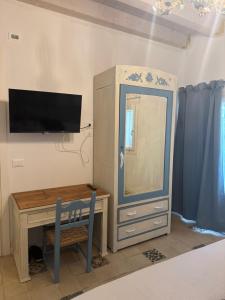 a bedroom with a desk and a dresser with a mirror at Casa Damasco in Pròzzolo