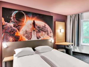 a room with a bed and a picture of a rocket at B&B Hotel Bremen-Altstadt in Bremen +22 photos