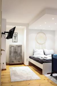 a white bedroom with a bed and a television at Ferienwohnung am Herzplatz 2 in Memmelsdorf