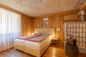 ein Schlafzimmer mit einem Bett in einem Zimmer mit Holzwänden in der Unterkunft Historic Hotel Ristorante La Stua in Cavalese + 122 Fotos