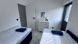 a bedroom with two beds and a dresser and a window at Marina Dziwnów Premium Haus 2 in Dziwnów