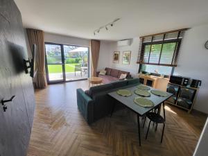 a living room with a green couch and a table at FLAUTA apartamenty in Iława