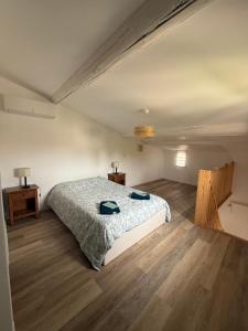 a bedroom with a bed and a wooden floor at La Rêverie in Le Thor