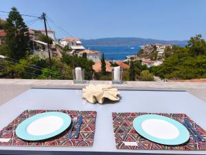 un tavolo con due piatti blu sopra con vista di Stamos house a Hydra Altre 7 foto