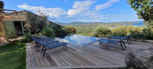a wooden deck with benches and a swimming pool at Villa Acciagina 10 pers PISCINE VUE MER PINARELLO Climatisée in Pinarellu