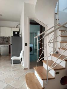 a staircase in a kitchen with a table and a chair at Casetta del Sole in Vallecrosia