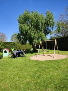 un parco con altalena incastonata nell'erba di NOUVEAU - GÎTE DU MOULIN A VENT - Zoo à 10 mn - Jeux pour enfants a Noyers-sur-Cher