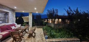 a patio with a couch and a table and chairs at Jardin miraculeux in Himare