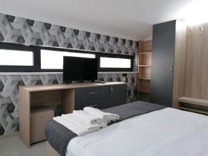 a bedroom with a bed with a desk and a television at гест хаус паркова 33 in Razgrad
