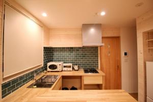 a kitchen with a counter with a sink and a microwave at Yotei View Tiny House in Kutchan