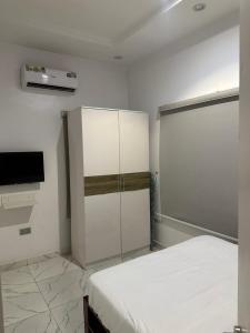 Un dormitorio con una cama y un televisor. en Euphoria apartments, en Lekki