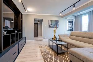 un salon avec un canapé et une télévision dans l'établissement Golden Glow Hideaway, à Bucarest