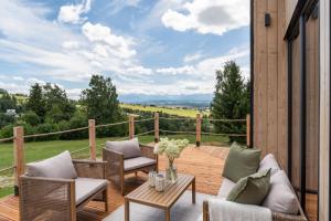 a patio with chairs and a table on a deck at Wichrowy Domek in Nowy Targ