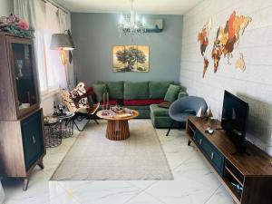 a living room with a green couch and a table at Caldera Premium Villa in Kavala