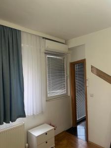 a room with a window and a dresser in it at Geon Apartament in Prishtinë
