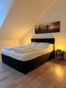 a bedroom with a bed with a painting on the wall at Dachterrasse für 4 Personen in Vienna
