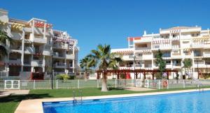 a hotel with a swimming pool in front of a building at Playa Sol 2 in Denia