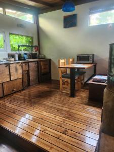 a kitchen with wooden floors and a table in a room at Cabaña el colibri in Mar del Plata