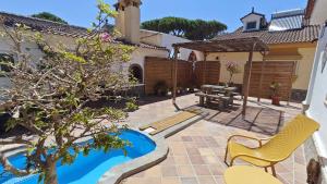 a patio with a table and a chair and a picnic table at 2-Person Studio, Private Splash Pool, 5 Min Beach in Novo Sancti Petri