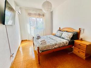 a bedroom with a bed and a dresser and a window at Milennium Holiday Apartment in Quarteira