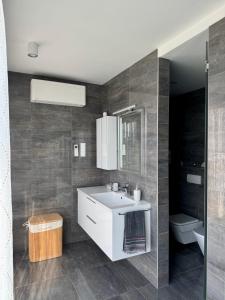 a bathroom with a sink and a toilet at Villapark apartman A-B 12 in Fonyód +10 photos