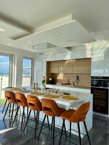 a kitchen with a large white island with chairs at Villapark apartman A-B 12 in Fonyód
