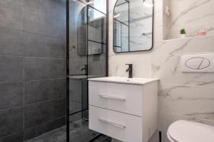 une salle de bain blanche avec lavabo et douche dans l'établissement Golden Glow Hideaway, à Bucarest 61 autres photos