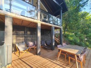 LohjaにあるVilla Mustikkamaaのパティオ(木製テーブル、デッキの椅子付)
